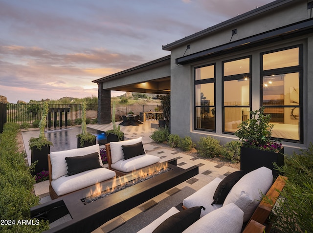 view of patio with fence and an outdoor living space with a fire pit