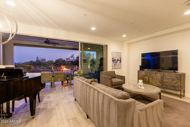 living room with light wood-type flooring and ceiling fan