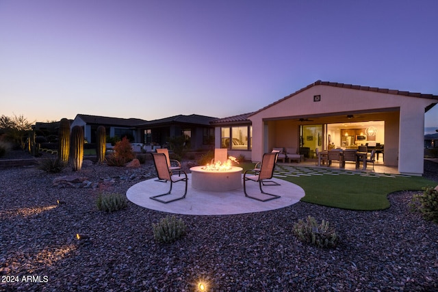 back house at dusk with a patio and an outdoor fire pit