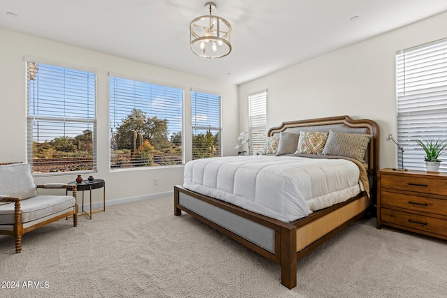 bedroom with multiple windows, carpet flooring, and a chandelier