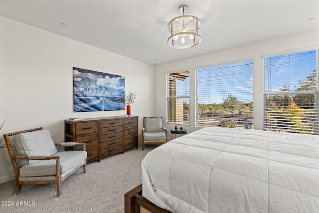 carpeted bedroom with a notable chandelier