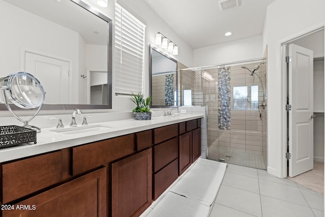 bathroom with a tile shower, tile flooring, and double vanity