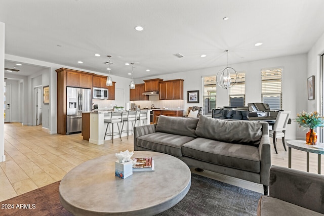 living room with an inviting chandelier and light hardwood / wood-style flooring