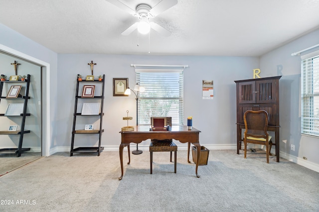 office space featuring light carpet and ceiling fan