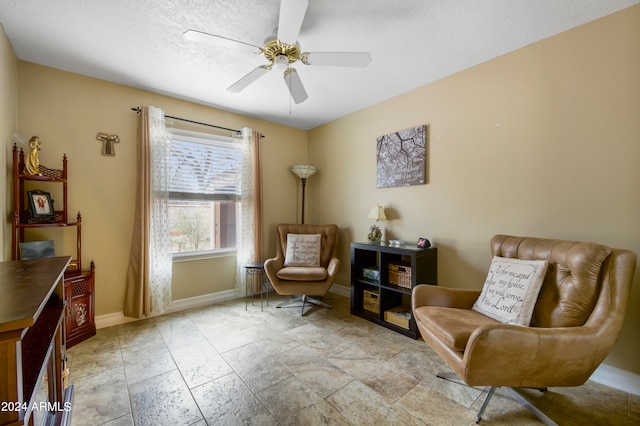 living area with ceiling fan and light tile flooring