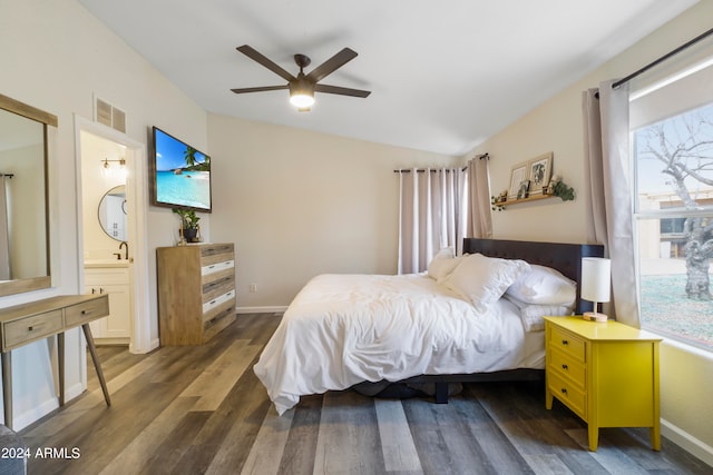 bedroom with ceiling fan, lofted ceiling, ensuite bath, and dark wood-type flooring