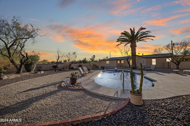 pool at dusk with a patio