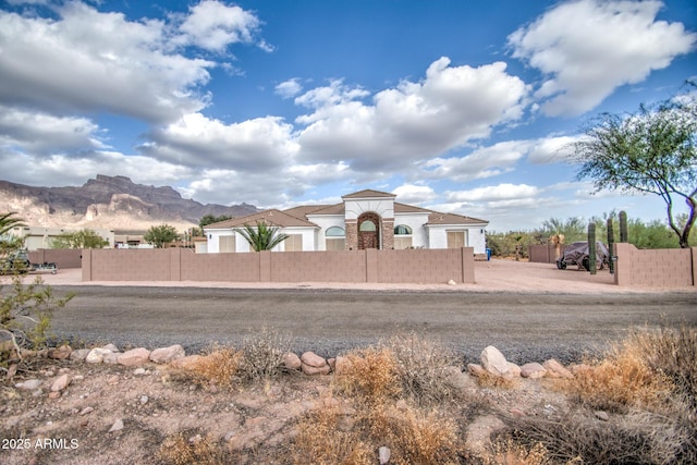 mediterranean / spanish-style home with a fenced front yard and stucco siding