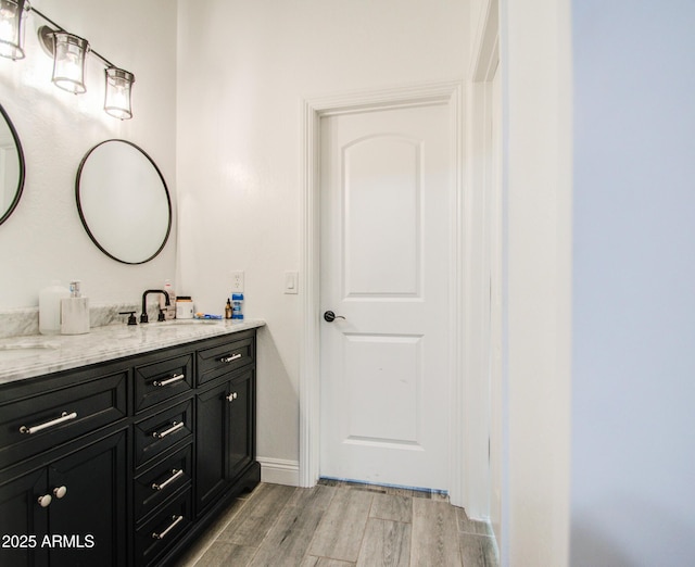 bathroom featuring wood finished floors, vanity, and baseboards