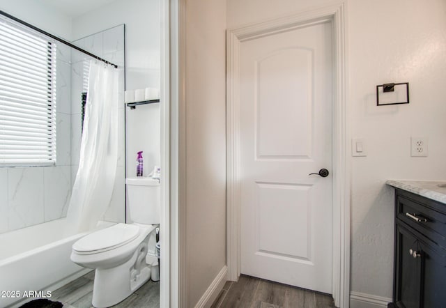 bathroom featuring toilet, wood finished floors, vanity, and shower / tub combo with curtain