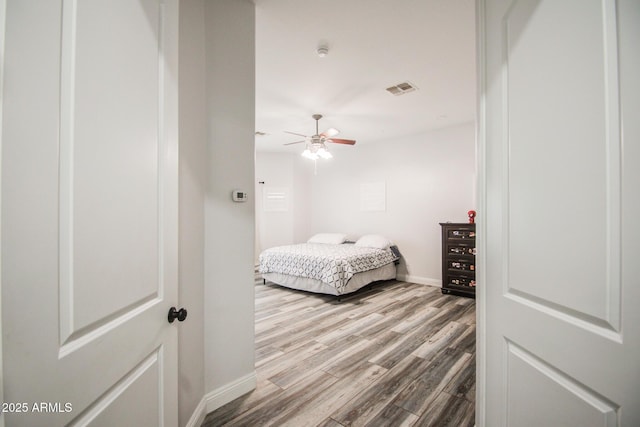 bedroom featuring baseboards, visible vents, and wood finished floors