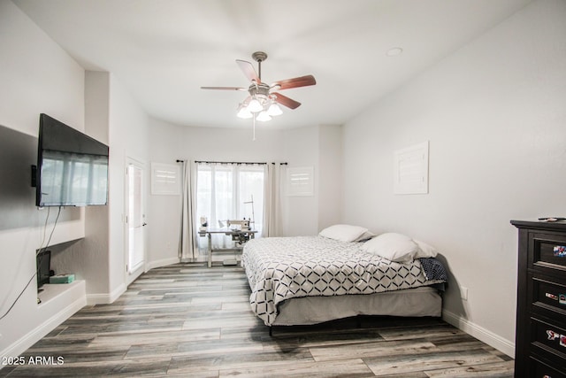 bedroom with ceiling fan, baseboards, and wood finished floors