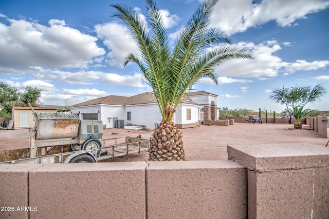 view of front of house with fence and central AC