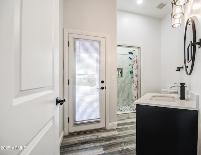 bathroom with a stall shower, visible vents, wood finished floors, vanity, and recessed lighting