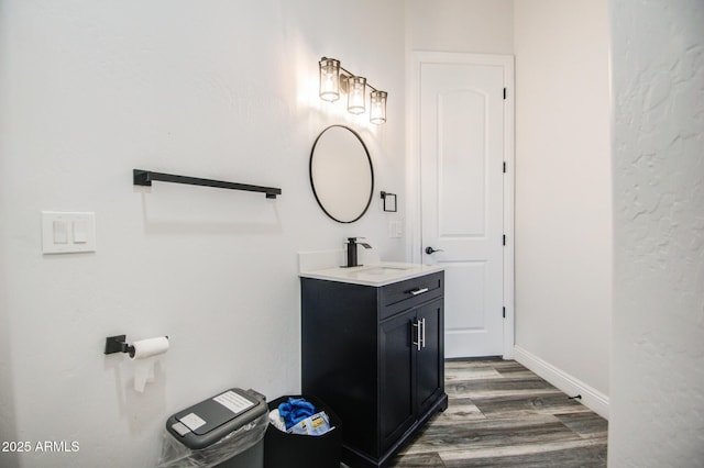 bathroom with baseboards, wood finished floors, and vanity