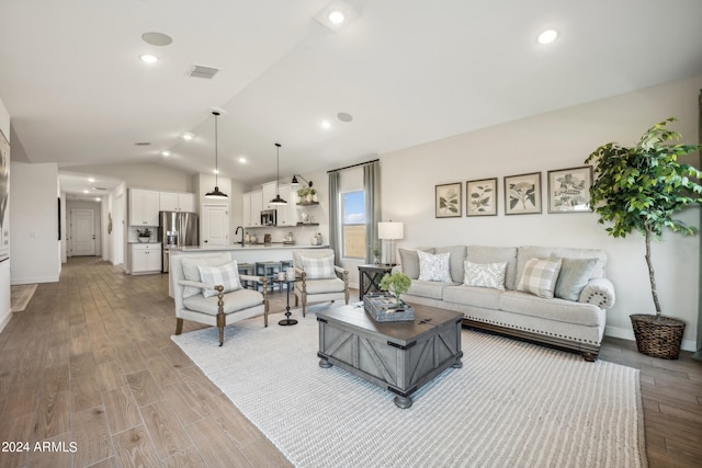 living room with lofted ceiling and light hardwood / wood-style flooring