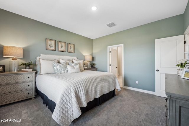 bedroom featuring dark carpet and connected bathroom