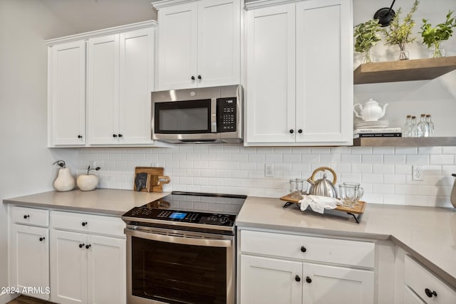 kitchen featuring white cabinets, stainless steel appliances, and backsplash