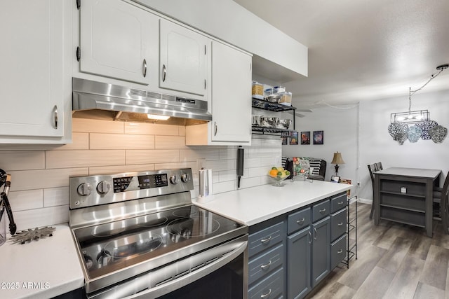 10374 W Deanne Dr, Sun City, AZ 85351 - kitchen featuring light countertops, light wood finished floors, stainless steel electric range, under cabinet range hood, and white cabinets