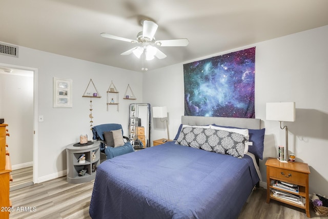 10374 W Deanne Dr, Sun City, AZ 85351 - bedroom featuring baseboards, visible vents, wood finished floors, and a ceiling fan