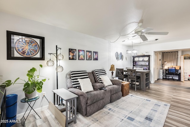 10374 W Deanne Dr, Sun City, AZ 85351 - living room with ceiling fan with notable chandelier, wood finished floors, and baseboards