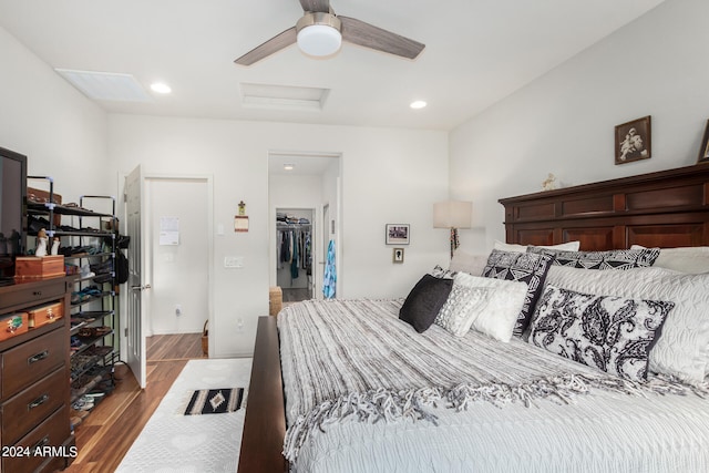 bedroom with a closet, a walk in closet, hardwood / wood-style flooring, and ceiling fan