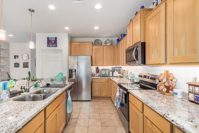 kitchen featuring light tile patterned floors, appliances with stainless steel finishes, light brown cabinetry, sink, and decorative light fixtures