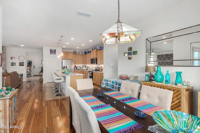 dining area with ceiling fan and dark hardwood / wood-style flooring