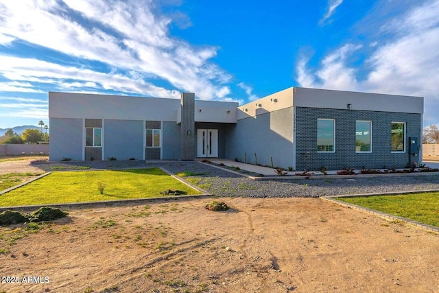 view of front of home with a front lawn and french doors