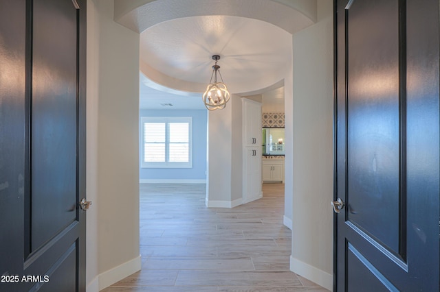 foyer with light hardwood / wood-style flooring and a chandelier