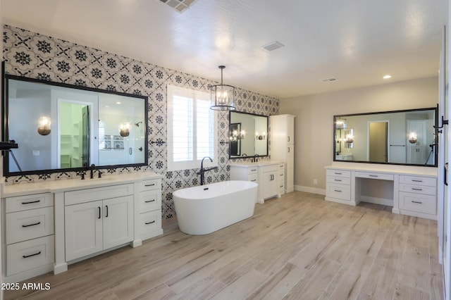 bathroom featuring a bath, vanity, and wood-type flooring