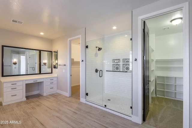 bathroom featuring vanity, a shower with shower door, and hardwood / wood-style floors