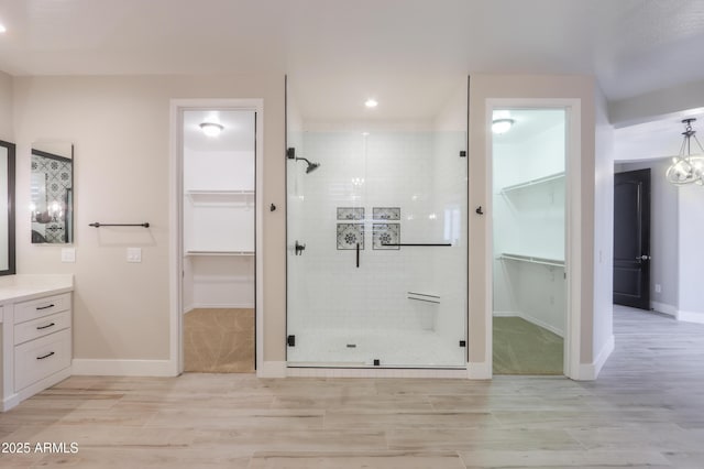 bathroom featuring vanity, a shower with shower door, and a notable chandelier