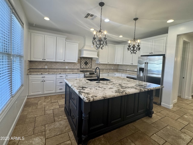 kitchen with sink, a center island with sink, appliances with stainless steel finishes, and white cabinetry