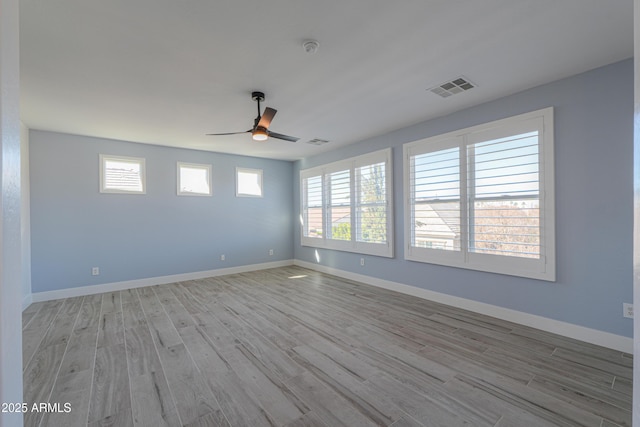 unfurnished room featuring a wealth of natural light, ceiling fan, and light hardwood / wood-style floors