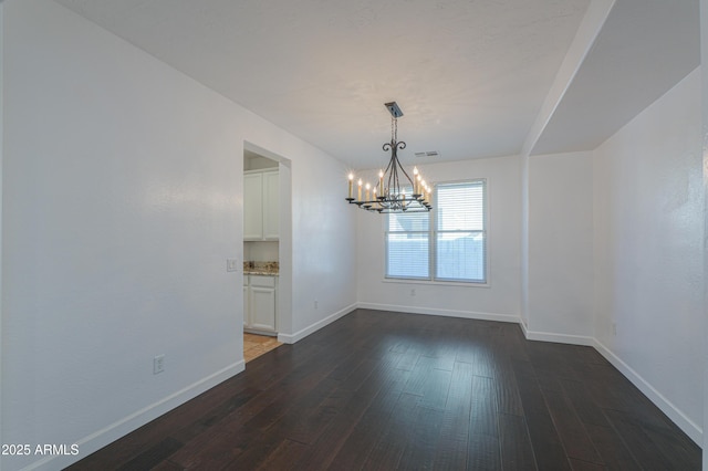 unfurnished dining area featuring a notable chandelier and dark hardwood / wood-style floors