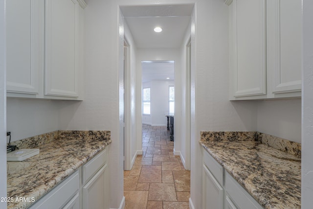 interior space with white cabinets and stone countertops