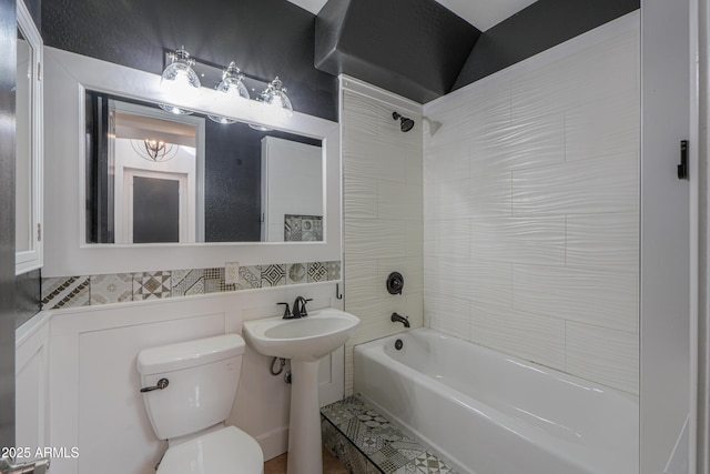 bathroom with toilet and tiled shower / bath combo