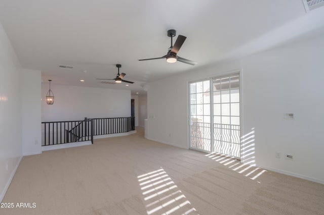 spare room featuring light colored carpet and ceiling fan