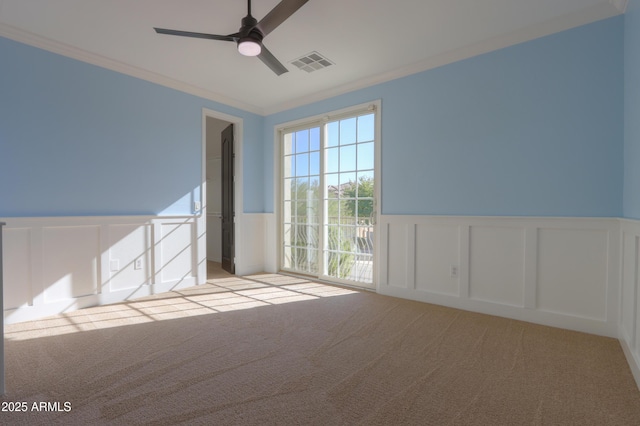 spare room featuring ornamental molding, ceiling fan, and light carpet