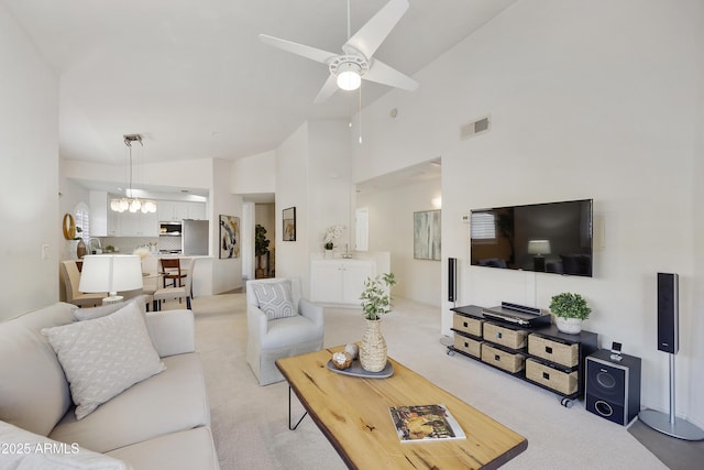 living area featuring high vaulted ceiling, ceiling fan, visible vents, and light colored carpet