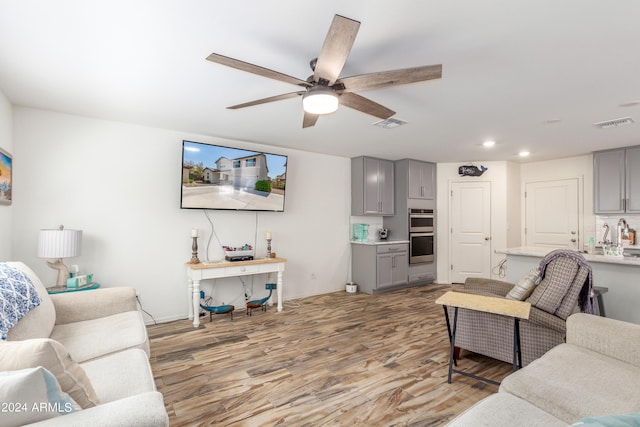 living room with ceiling fan and hardwood / wood-style floors