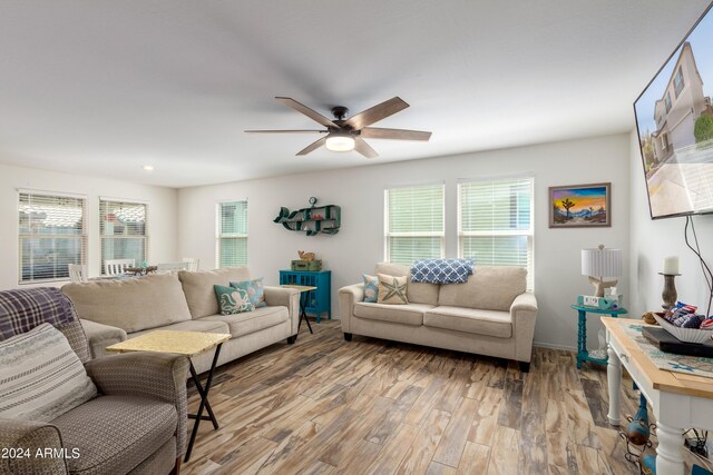 living room with ceiling fan and light hardwood / wood-style flooring