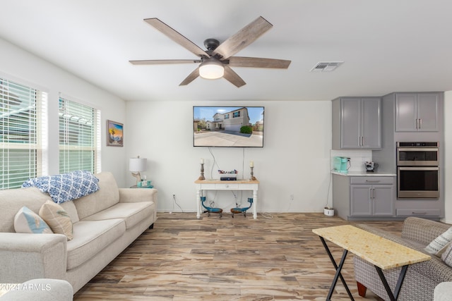 living room featuring ceiling fan and light hardwood / wood-style flooring