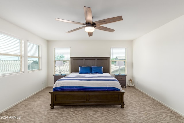 carpeted bedroom with ceiling fan and multiple windows