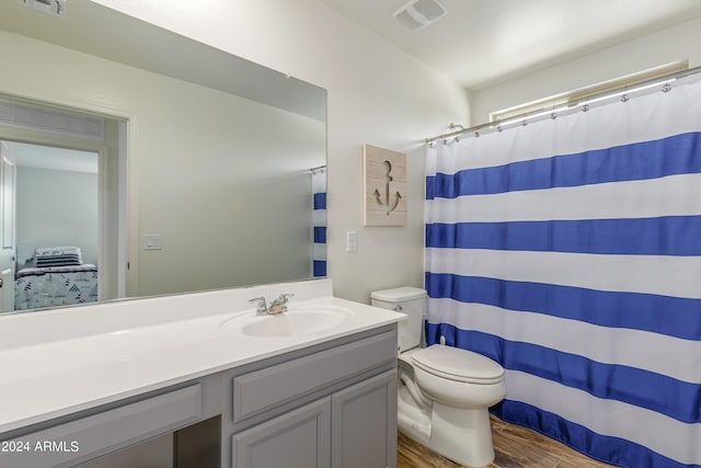 bathroom with vanity, hardwood / wood-style flooring, curtained shower, and toilet