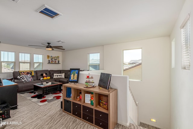 carpeted living room with ceiling fan and a wealth of natural light