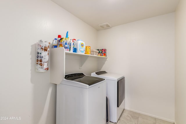 laundry area featuring light tile patterned flooring and washing machine and dryer