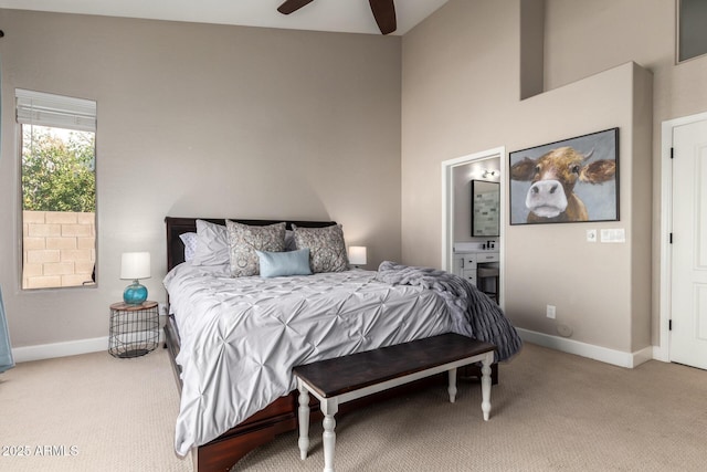 bedroom featuring baseboards, connected bathroom, and light colored carpet