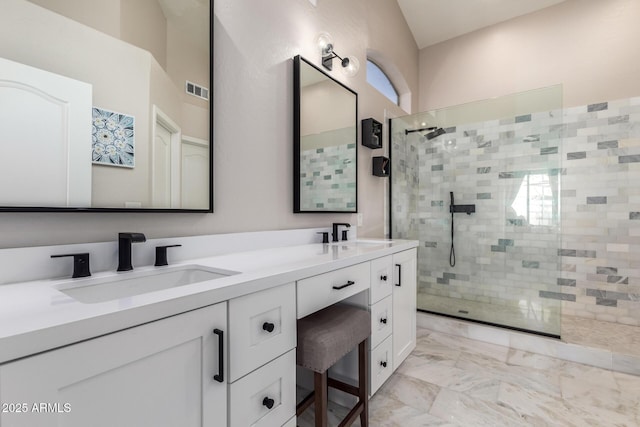 full bath featuring a walk in shower, marble finish floor, double vanity, and a sink